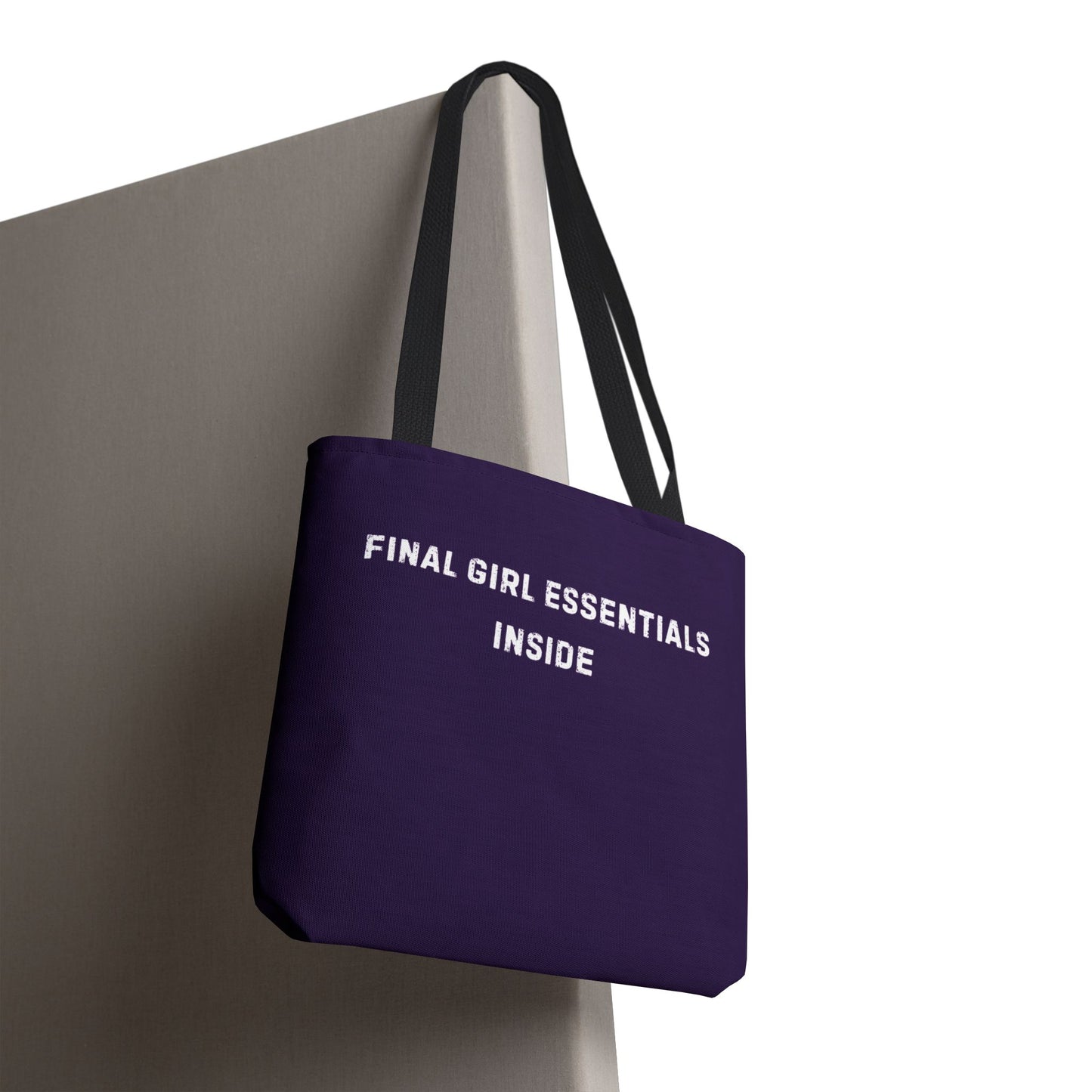 Purple tote bag with 'FINAL GIRL ESSENTIALS INSIDE' text on a white background